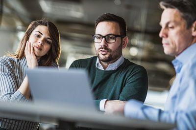 Young couple using computer with their business insurance agent on a meeting in the office.